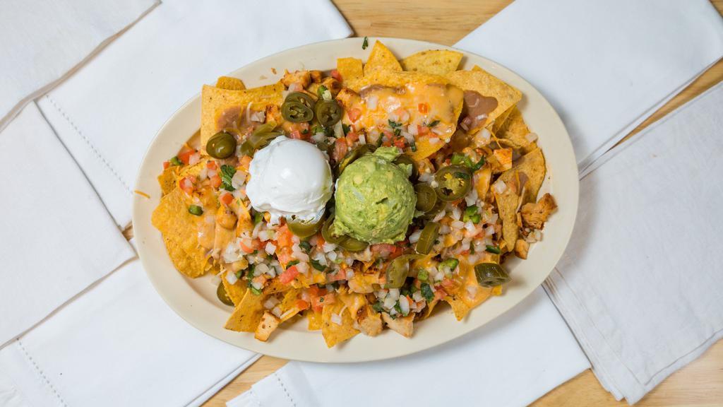 Loaded Nachos · Fresh made and covering a full plate. Topped in meat, beans, cheese, served with guacamole and sour cream.
