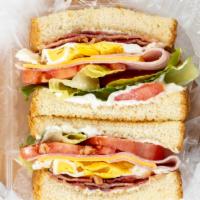Club Sandwich · Club sandwich on toasted white bread with mayo, ham, cheese, egg, bacon, lettuce, and tomato.