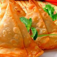 Vegetable Samosa · Two pastries filled with potatoes and green peas.