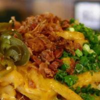 Cardiac Fries · Fried Idaho Potatoes topped with mounds of Cheddar Cheese, Chives, Bacon Bits, & Pickled Jal...