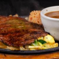 Carne Asada · Served on a bed of rice with one cheese enchilada, guacamole, mango, pico de gallo, and bean...