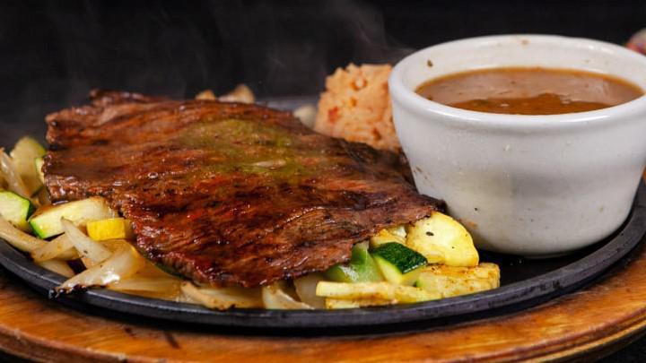 Carne Asada · Served on a bed of rice with one cheese enchilada, guacamole, mango, pico de gallo, and bean soup.