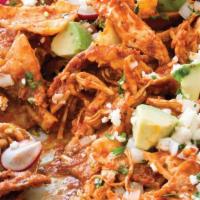 Chilaquiles · Tortilla chips in a red or green sauce and cheese served with two eggs and beans.