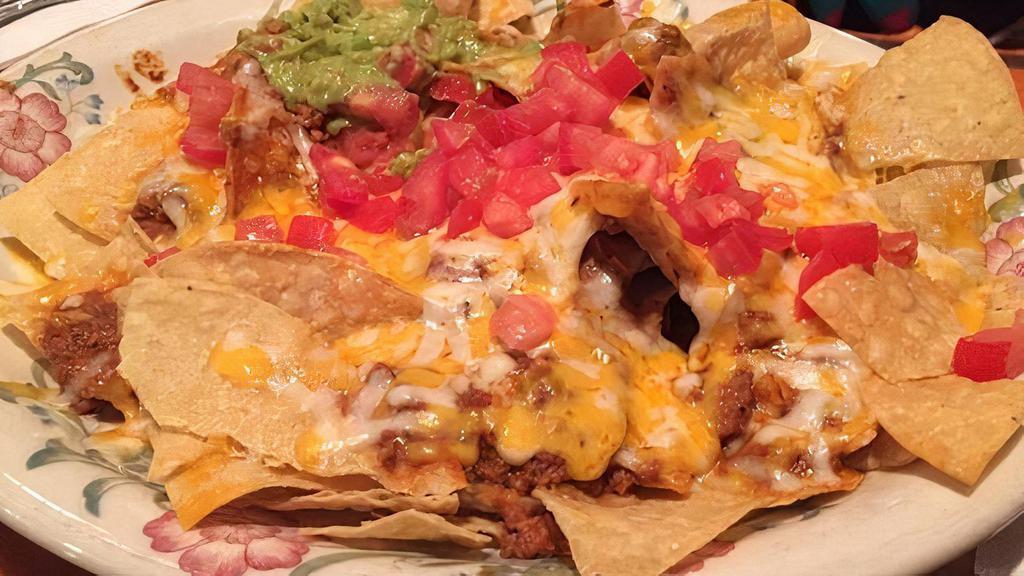 Nachos A La Mexicana · Your choice of chicken or ground beef, beans, jalapeños, tomatoes and onions.