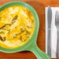 Chile Con Queso · Fresh long green-chile strips, sautéed onions, and loads of thick melted cheese.