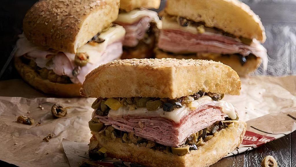 Whole Muffaletta · A New Orleans original! Grilled, crusty Muffaletta bread is spread to the edges with our family-recipe olive mix and provolone is melted over layers of sliced meat.