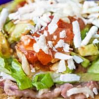 Tostada · Freshly fried single corn tortilla layered with refried beans, lettuce, tomatoes and cheese....