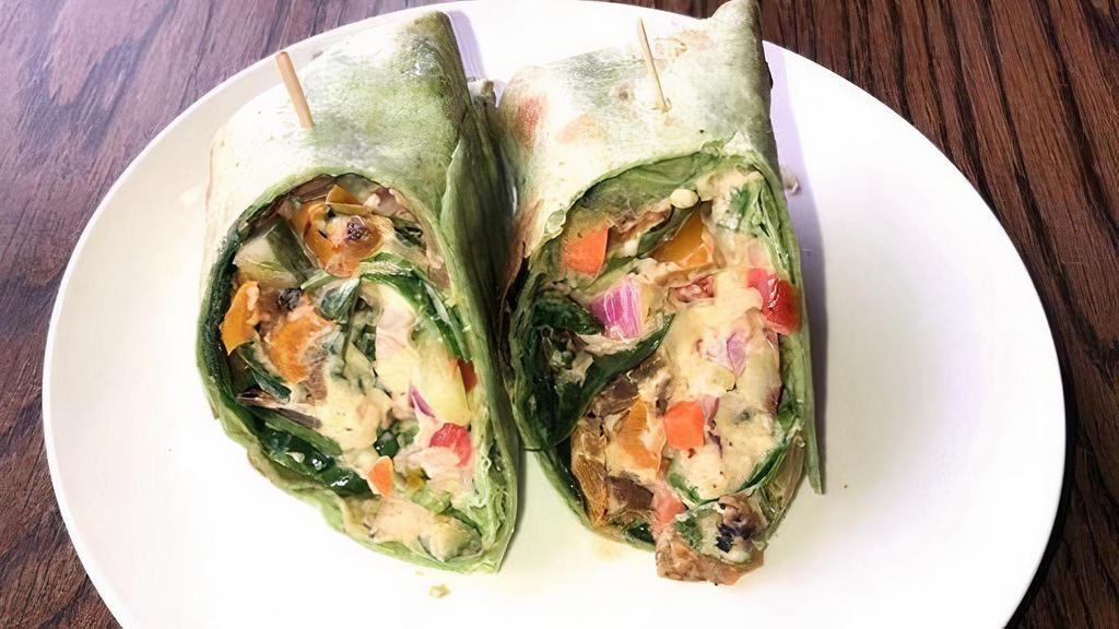 Mediterranean Hummus Wrap · Fresh hummus, cucumber salad, pickled carrot, spinach, red wine vinegar, olive oil, herbs, roasted bell pepper & onions on a garden herb wrap