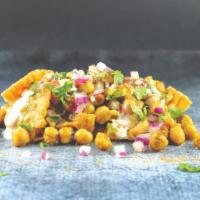 Samosa Chaat · Street Style. Stir-fried chickpeas, onions, tomatoes, and cilantro served atop a samosa cove...