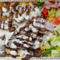 Gyro Plate Over Rice · Tender lean lamb meat chopped and grilled over basmati rice and side salad. Served with whit...