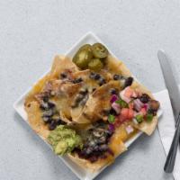 The Macho Nachos · Vegetarian. Tortilla chips with black beans, jalapeño peppers, guacamole, and sour cream.
