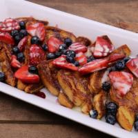 Grand Berry Dream French Toast · Sliced brioche stuffed with sweet cream
cheese glaze, topped with blueberry coulis,
fresh st...