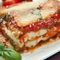Eggplant Parmigiana · Battered and baked with mozzarella and marinara sauce. Includes salad and two garlic rolls.