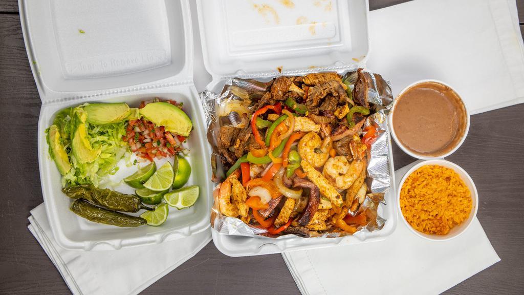 Parillada (Steak, Grilled Chicken, Shrimp) · A mix of Steak Fajita, Shrimp, Grilled Chicken & Sausage platter served with grilled onions,  bell peppers, lettuce, pico de gallo, avocado, and a side of rice and beans.