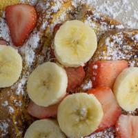French Toast · Three slices of sourdough bread grilled and topped with strawberries, bananas and powdered s...