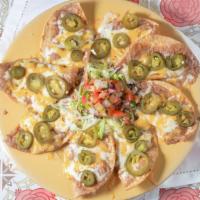 Texas Nachos* · Eight crisp corn tortillas topped with refried beans, mixed cheese, lettuce, pico de gallo &...