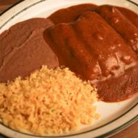 Tamale Dinner · Four Pork tamales topped with ground beef gravy served with rice and beans.