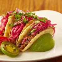 Thai Tacos With Pork · Three crispy wonton shells stuffed with wok seared pulled pork, topped with pickled bean spr...