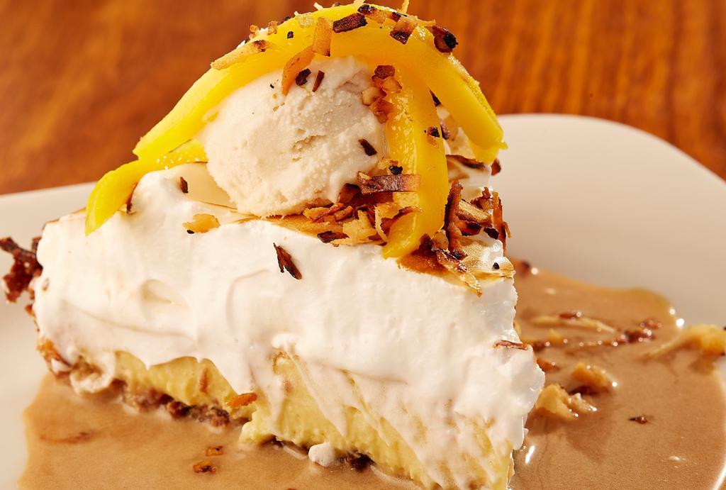 Coconut Cream Pie · Scratch pie layered with a coconut macaroon crust, coconut custard and fresh meringue. Served over tamarind-caramel and topped with housemade coconut gelato and sliced mango.
