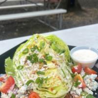 Wedge Salad · Wedge Salad topped Blue Cheese Crumble, Bacon, Tomato, Green Onion & Ranch Dressing. Add Chi...