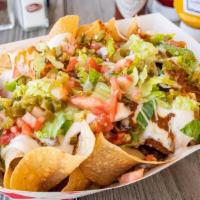 Redneck Nachos · Fresh cooked chips covered in chili & queso, topped with shredded lettuce, tomatoes & jalape...