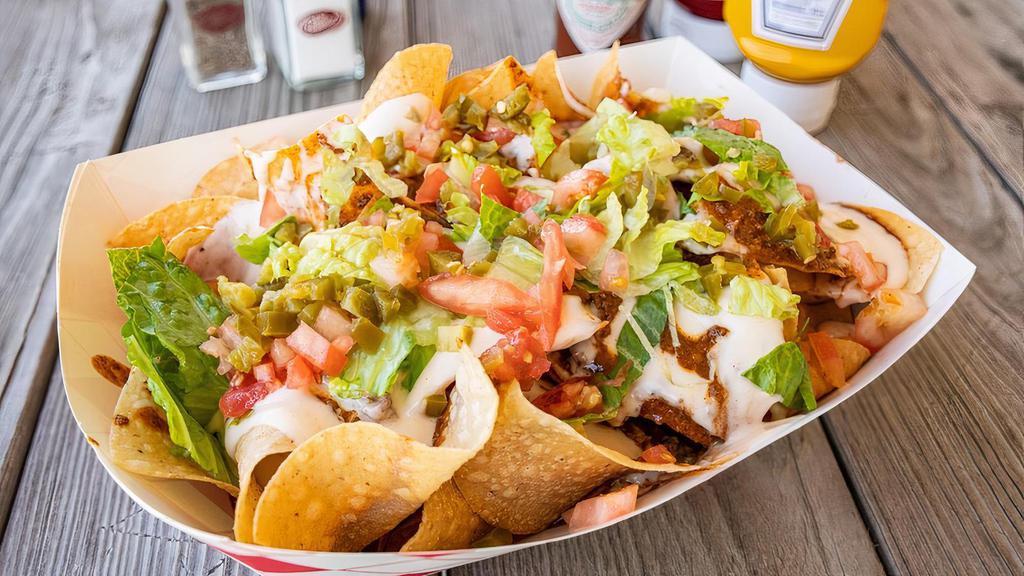 Redneck Nachos · Fresh cooked chips covered in chili & queso, topped with shredded lettuce, tomatoes & jalapenos.