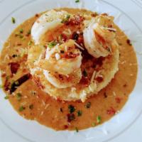 Not Your Grandma Shrimp & Grits · Creamy cheese corn grit cake deep fried surrounded by a parmesan seafood tomato sauce topped...
