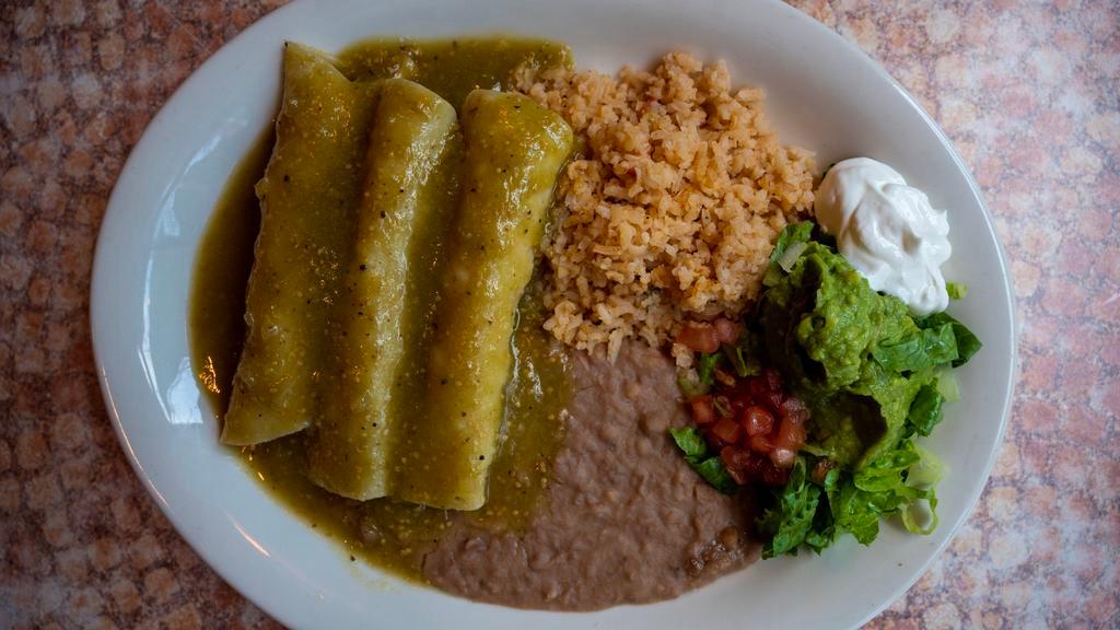 Enchiladas Verdes · Three soft corn tortillas stuffed with shredded chicken and topped with our verde sauce and sour cream. Served with Spanish rice, refried beans, and guacamole salad. 

*Entrée comes with 1 tortilla.