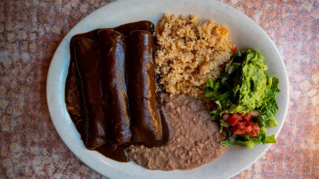 Enchiladas De Mole · Three chicken enchiladas topped with mole poblano sauce. Served with Spanish rice, refried beans, and guacamole salad. 

*Entrée comes with 1 tortilla.