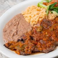 Beef Steak “Ranchero” · Beef tenderloin topped with spicy Ranchero sauce. Served with Spanish rice, refried beans, a...