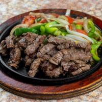 Beef Fajitas · Beef fajitas served with tomatoes, peppers and onions. Accompanied with Spanish rice, refrie...