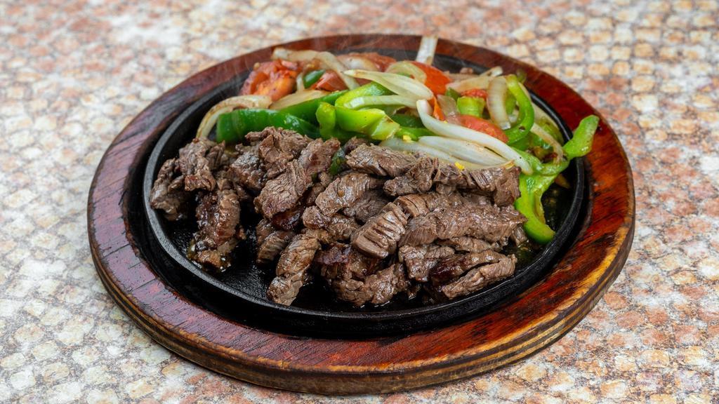 Beef Fajitas · Beef fajitas served with tomatoes, peppers and onions. Accompanied with Spanish rice, refried beans, guacamole, and pico de gallo.

*Portion for 1 comes with 3 tortillas. Portion for 2 comes with 6 tortillas.