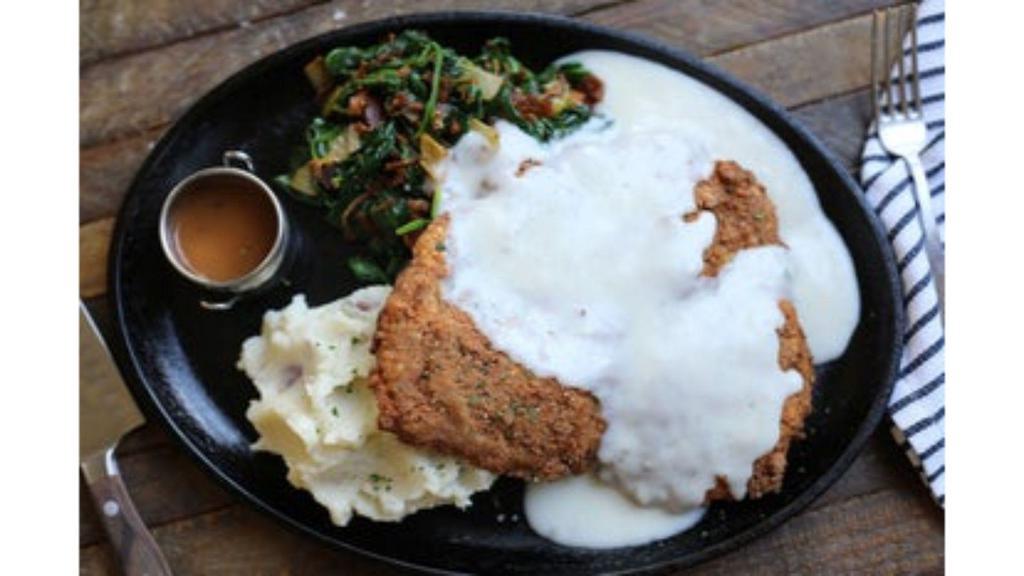 Chicken Fried Ribeye · certified angus beef® ribeye steak hand-breaded with our buttermilk batter, sautéed spinach with bacon, red skin potato mash, smothered in white country gravy + brown gravy on the side for dipping [1540 cal]