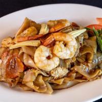 Ls20. Drunken Noodles · Spicy stir-fried flat noodles with carrots, baby corn, tomatoes, garlic, and basil leaves in...