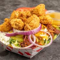 The Barnyard Cobb · Chicken nuggets, bacon, eggs, pickled peppers, pickles, tomatoes, cheddar and onion tossed i...