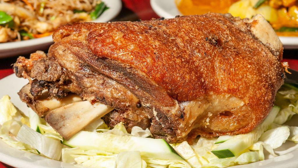 Crispy Pata · Tender braised crispy skin-on pork shank, perfectly seasoned with simple salt and pepper served on a bed of lettuce and cucumber.