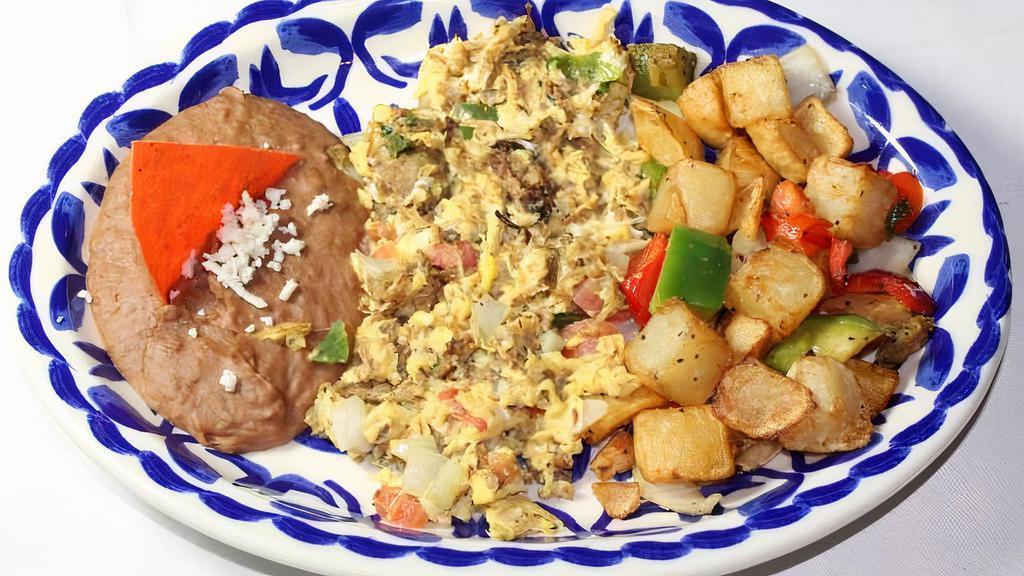 Machacado · Our famous Homemade tender shredded Mexican Style Beef Jerky scrambled with Eggs, Tomatoes, Onions and Jalapenos. Served with Breakfast Potatoes, Salsa Ranchero, Refried Beans and Tortillas