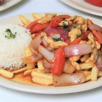 Pollo Saltado · Stir-fried chicken with sautéed tomatoes and onions served with fries and rice.