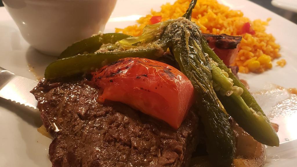 Carne Asada · Grilled steak over onions, peppers, tomatoes, and jalapenos. Served with rice and charro beans.
