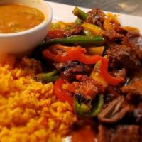 Guiso · Fajita beef simmered in red chile stew with tomatoes, jalapenos, and onions. Served with cor...