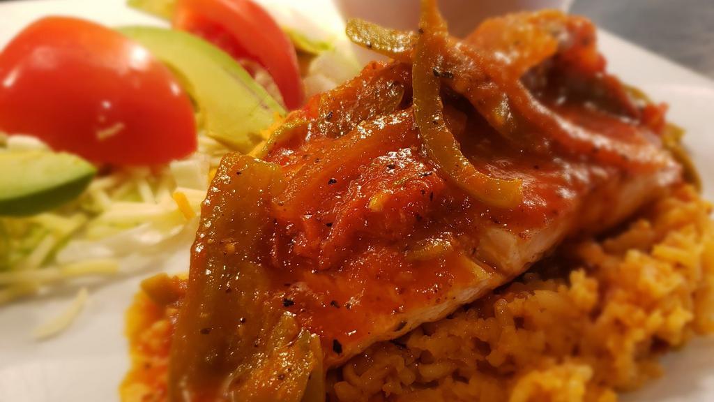 Pescado Veracruzana · Pan seared salmon topped with classic salsa veracruzana, served with rice and charro beans.