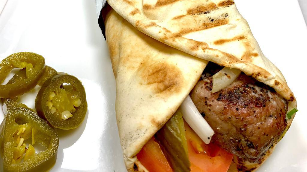 Lamb Kabob Wrap · Freshly Grilled Lamb prepared by our master Chef  then warped in fresh Pita Bread with freshly sliced tomatoes, onion, pickles and tahina sauce and toasted to perfection
