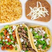 Plato De Tacos / Taco Plate · Tres unidades de tacos acompañados de arroz y frijoles. / Three tacos with rice and beans.