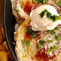 Huevos Rancheros · Corn tortillas topped with refried beans, bacon, sautéed peppers & onions, warm salsa, queso...