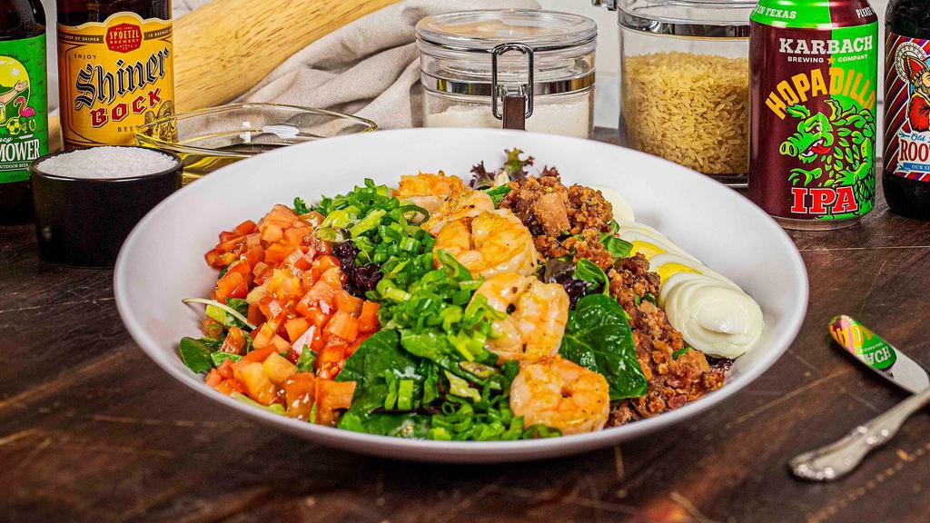 Cajun Cobb Salad · Mixed baby greens tossed with bleu cheese dressing, topped with cajun grilled chicken or shrimp, bleu cheese crumbles, bacon, green onions, heirloom tomatoes, and hard-boiled egg.