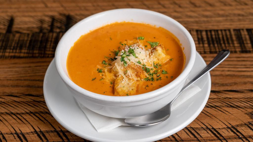 Tomato Basil Soup · Cup, Topped with Parmesan cheese and house-made croutons.