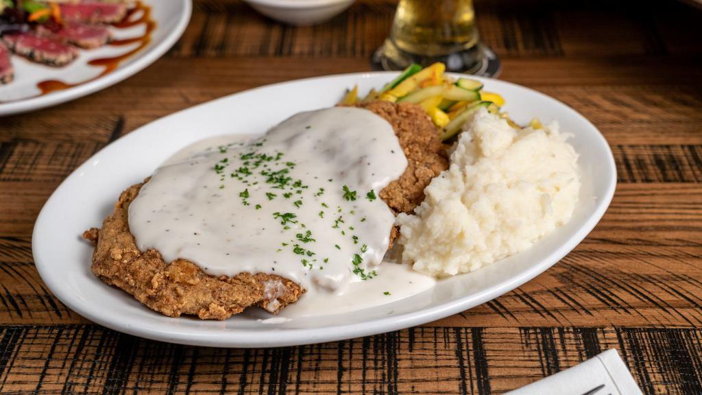 Country Fried Steak · Signature Dish. Garlic whipped potatoes, sautéed vegetables and cream gravy.