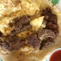 Texan · Slices of beef fajita and eggs in a flour or corn tortilla.