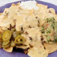 Nachos · Stuffed with queso and your choice of meat and side of sour cream, jalapeños, and guacamole.