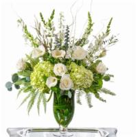 Heavenly  · Classic White and Ivory Premium Blooms with premium greenery and filler in a hurricane glass...